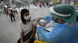 Seorang petugas kesehatan menyuntikkan dosis vaksin COVID-19 Pfizer kepada warga di pusat vaksinasi di Bangkok, Thailand, Jumat (4/2/2022). (AP Photo/Sakchai Lalit)