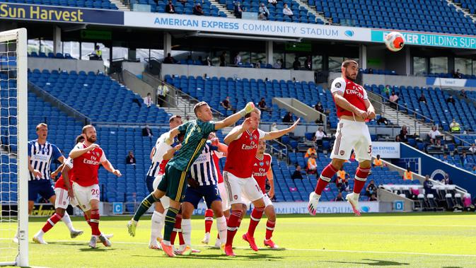 Bek Arsenal, Sead Kolasinac (kanan) menyundul bola saat melawan Brighton & Hove Albion pada lanjutan pertandingan Liga Inggris di The American Express Community Stadium, Sabtu (20/6/2020). Sempat unggul, Arsenal justru tumbang 1-2 di tangan Brighton. (Gareth Fuller/Pool via AP)