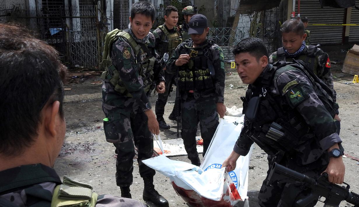 Polisi mengevakuasi kantong jenazah pasca ledakan bom di Gereja Katolik Jolo, Filipina Selatan, Minggu (27/1). Ledakan pertama terjadi tepat ketika Misa Minggu berlangsung, sekitar pukul 08.45 waktu setempat. (Nickee Butlangan/AFP)
