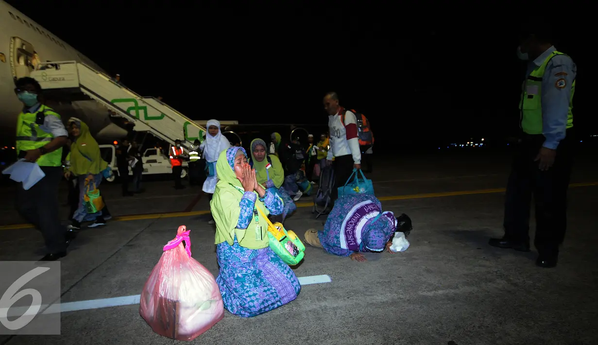 Beberapa jamaah haji Indonesia dari kloter I DKI Jakarta melakukan sujud syukur saat tiba di Bandara Halim Perdanakusuma Jakarta, Selasa (29/9/2015). Sebanyak 440 jamaah dengan tiba sekitar pukul 18.30 WIB. (Liputan6.com/Helmi Fithriansyah)
