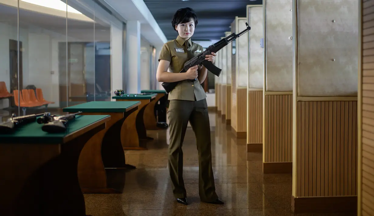 Dalam foto yang diambil pada 29 Juli 2018, seorang instruktur menembak bernama Kim Ju Yang (20) memegang senapan serbu buatan Korea saat berpose untuk sesi foto di Meari Shooting Range, Pyongyang di Korea Utara. (AFP PHOTO / Ed JONES)