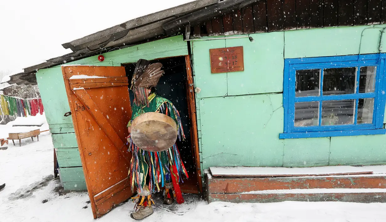 Seorang dukun menabuh alat musik saat mengusir roh jahat di kediaman pelanggannya di Kota Kyzyl, Tuva, Siberia, Rusia, (3 /11). (REUTERS/Ilya Naymushin)