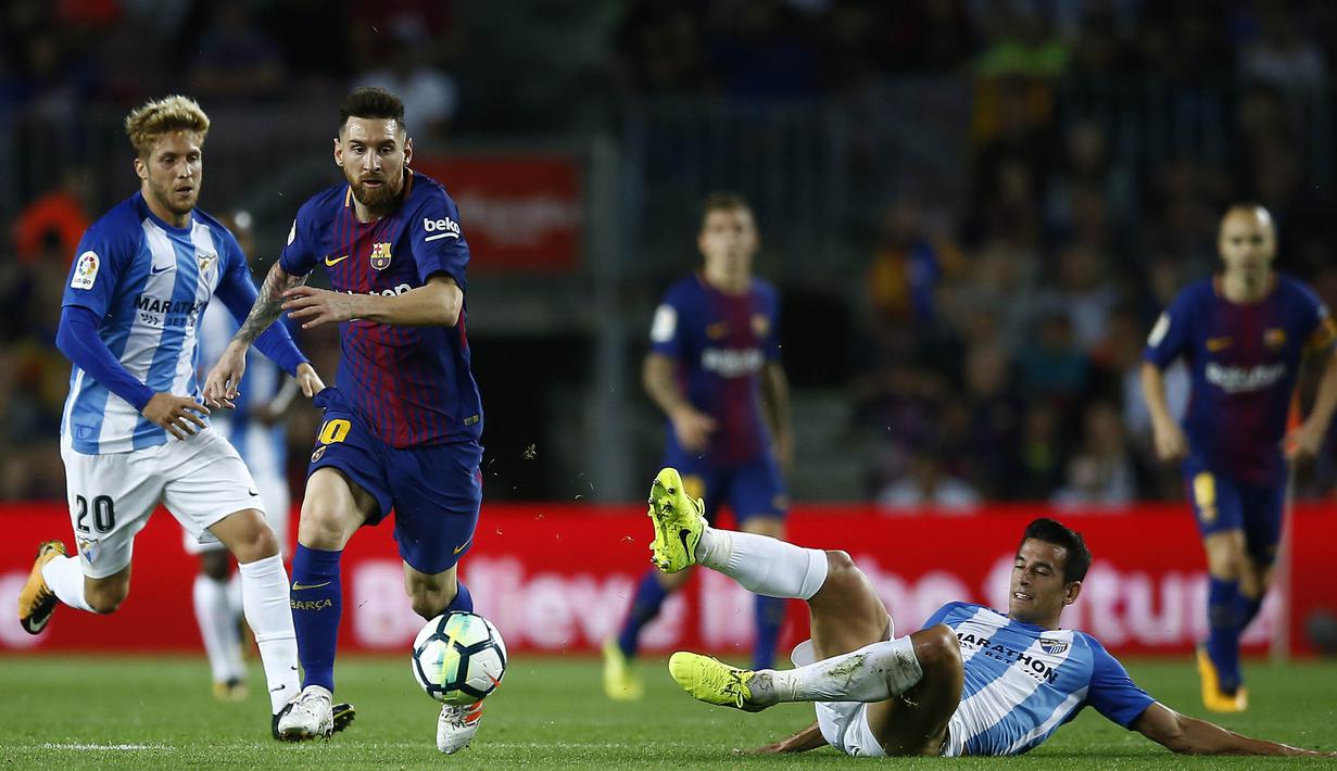 Gelandang Barcelona, Lionel Messi, melewati hadangan para pemain Malaga pada laga La Liga di Stadion Camp Nou, Barcelona, Sabtu (21/10/2017). Barcelona menang 2-0 atas Malaga. (AP/Manu Fernandez)
