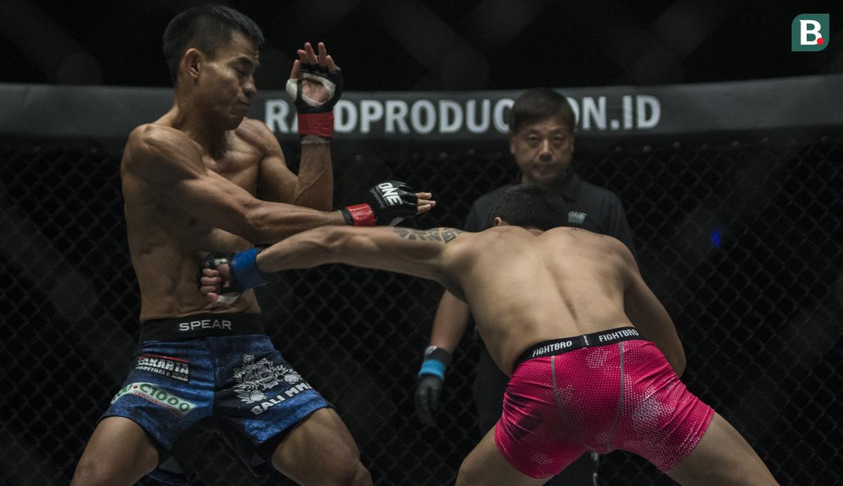 Atlet MMA Indonesia, Stefer Rahardian, terkena pukulan atlet MMA China, Peng Xue Wen, pada kelas strawweight di JCC Senayan, Jakarta, Sabtu (22/9/2018). Stefer Rahardian kalah dari Peng Xue Wen. (Bola.com/Vitalis Yogi Trisna)