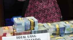 Pemilik rekening PT Surya Subur Jaya yang diduga terlibat dalam kejahatan TPPU, IN ditunjukkan beserta barang bukti uang di Kantor BNN, Jakarta, Selasa (17/7). IN diduga menerima dana dari bandar narkoba sebesar Rp 3,9 Miliar. (Liputan6.com/Arya Manggala)