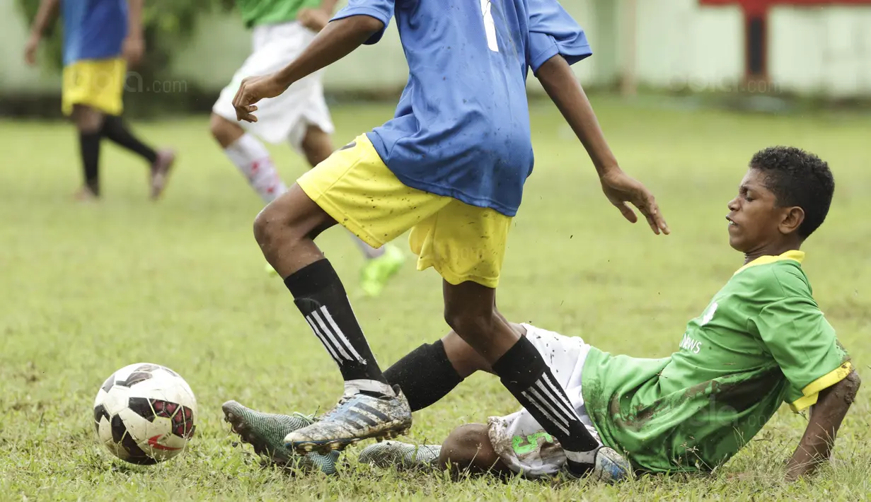 Pemain SSB Hatu berebut bola dengan pemain SSB Maehanu pada semifinal turnamen Liga Remaja UC News di Lapangan Masariku Yonif 733, Ambon, Rabu (29/11/2017). (Bola.com/Peksi Cahyo)