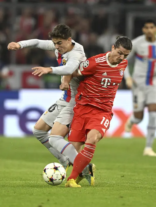 Gelandang Bayern Munchen Marcel Sabitzer berebut bola dengan gelandang Barcelona Gavi pada matchday 2 Grup C Liga Champions 2022/2023 di Allianz Arena, Rabu (14/9/2022) dini hari WIB. Barcelona takluk 0-2 saat dijamu Bayern Munchen. (AP Photo/Andreas Schaad)