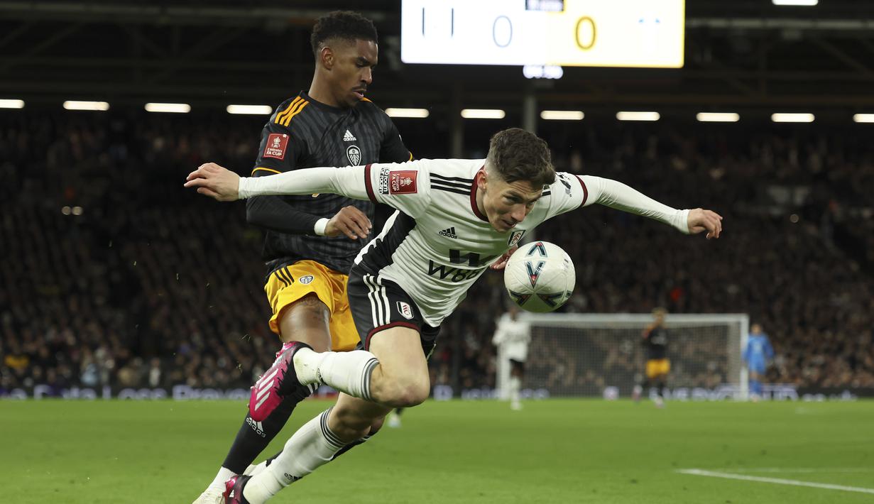 Bek Leeds United Junior Firpo berebut bola dengan gelandang Fulham Harry Wilson pada pertandingan putaran kelima Piala FA 2022/2023 di Craven Cottage di London, Rabu (28/2/2023) dini hari WIB. Fulham menyingkirkan Leeds United dengan kemenangan 2-0. (AP Photo/Ian Walton)