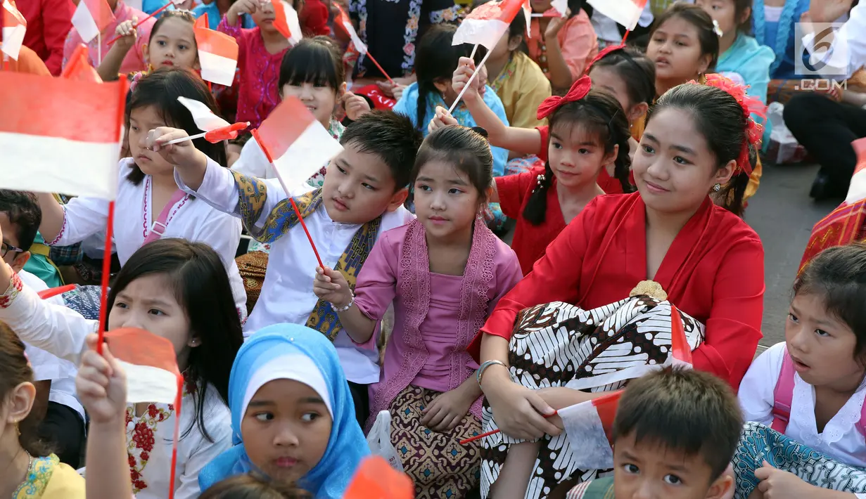 Beberapa anak-anak mengibarkan bendera Merah Putih saat gelaran Harmoni Indonesia 2018 di Kompleks Gelora Bung Karno, Jakarta, Minggu (5/8). Presiden RI, Joko Widodo hadir dalam acara bernyanyi bersama lagu kebangsaan. (Liputan6.com/Helmi Fithriansyah)