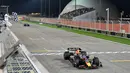 Pebalap Red Bull, Max Verstappen melintasi garis finis saat Formula 1 GP Bahrain 2023 yang berlangsung di Sirkuit Internasional Bahrin, Sakhir, Minggu (05/03/2023) WIB. (AFP/Andrej Isakovic)