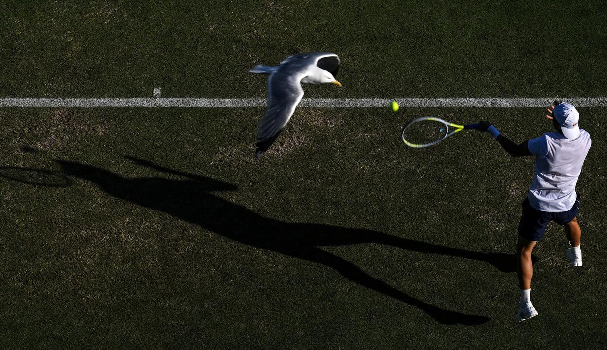 Petenis Inggris, Ryan Peniston berusaha mengembalikan bola menuju petenis Spanyol Pedro Martinez saat burung camar terbang di atasnya saat putaran 8 pertandingan tenis tunggal putra pada hari keempat turnamen tenis Eastbourne International di Eastbourne, Inggris pada 22 Juni 2022. (AFP/Glyn Kirk)