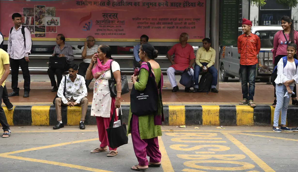 Seorang perempuan menunggu bus  New Delhi Transport Corporation untuk melakukan perjalanan gratis di New Delhi, 29 Oktober 2019. Pemerintahan teritorial ibu kota India, New Delhi, menerapkan kebijakan menggratiskan seluruh rute bus untuk kaum perempuan sejak 29 Oktober. (Sajjad HUSSAIN/AFP)
