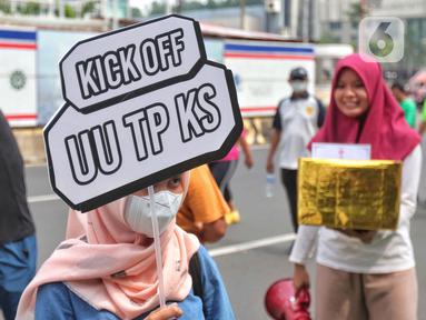 Masyarakat membawa poster sosialisasi UU TPKS saat Car Free Day di kawasan Bundaran HI, Jakarta, Minggu (25/9/2022). Kampanye Undang-undang Tindak Pelaku Kekerasan Seksual (UU TPKS)  tersebut dilakukan agar masayarakat dapat mengetahui UU ini menjadi payung hukum bagi korban kekerasan seksual. Bukan hanya korban yang bisa melaporkan tindak kekerasan seksual, tapi bagi yang mendengar atau melihat juga bisa melaporkan. (Liputan6.com/Angga Yuniar)