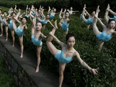 Sejumlah wanita melakukan gerakan Yoga di sebuah perkebunan teh untuk mengisi program TV jepang di Hangzhou , Provinsi Zhejiang , Cina , 17 April , 2016. Kita akan melihat berbagai kebiasaan unik warga Cina. (REUTERS / Stringer)