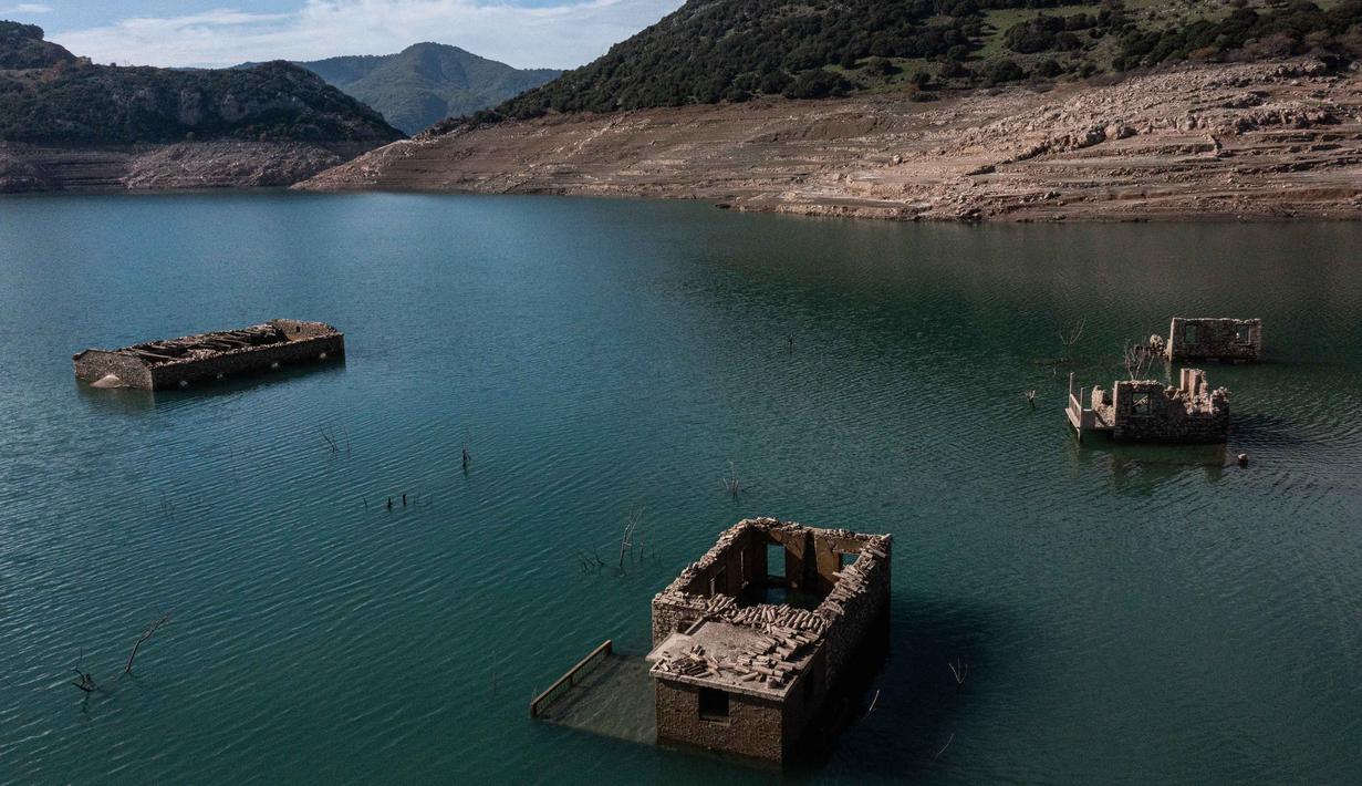 Foto ini menunjukkan sisa-sisa rumah yang muncul kembali ketika permukaan danau buatan Mornos menurun akibat kekeringan, di desa Kallio, sekitar 240 km barat laut Athena, Yunani pada 3 November 2025. (Angelos TZORTZINIS/AFP)