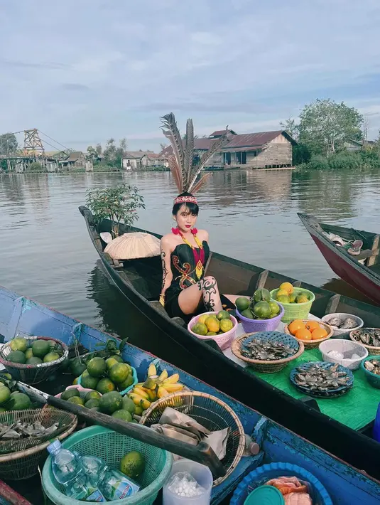 Ia tampil garang pakai kostum Dayak hitam, lengkap dengan hiasan kepala bulu dan tato di tubuhnya.