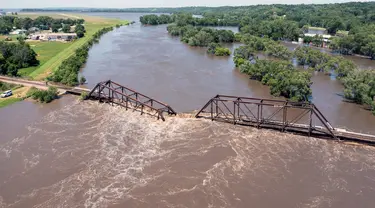 Air banjir melintasi jembatan kereta api yang runtuh di atas Sungai Big Sioux di dekat North Sioux City, South Dakota, pada hari Senin, 24 Juni 2024. (AP Photo/Josh Jurgens)