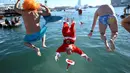 Para peserta tradisi lomba renang unik saat natal di pelabuhan tua Barcelona (Port Vell Barcelona), Spanyol, Senin (25/12/2023) waktu setempat. (AFP/Josep Lago)