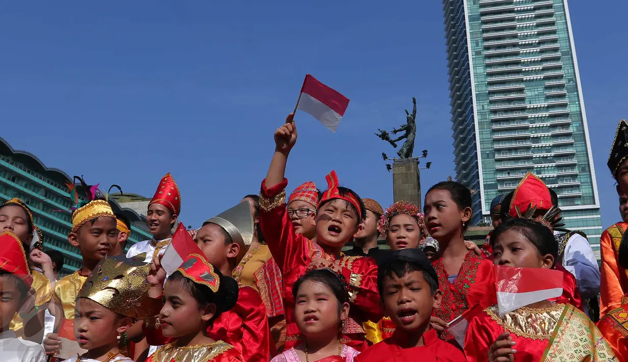 <p>Seorang murid sekolah minggu Gereja Eban Haezer mengenakan baju adat sambil melambaikan bendera nasional di Bundaran HI Jakarta, Minggu (21/8). Menyanyikan lagu Indonesia Raya dan lagu daerah, mereka memperingati HUT RI ke 71. (Liputan6.com/Angga Yuniar)</p>