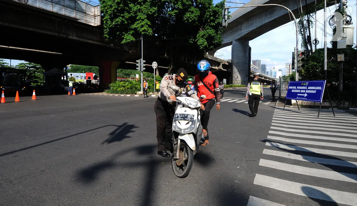 Polisi memberhentikan pengendara sepeda motor saat penyekatan masa PPKM Darurat di Perempatan Fatmawati, Jakarta, Senin (12/7/2021). Penyekatan berlangsung hingga pukul 10.00 WIB. (merdeka.com/Arie Basuki)