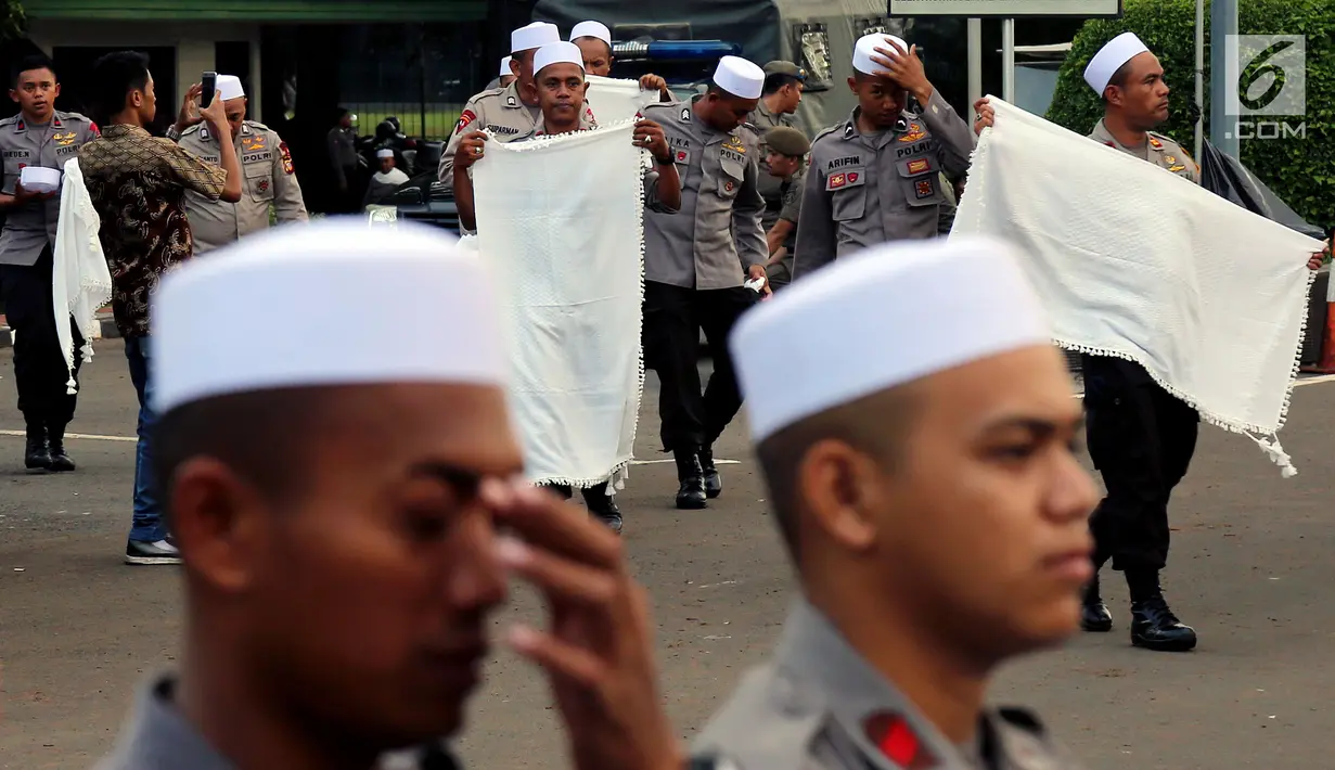 Personel Brimob yang tergabung dalam Pasukan Dzikir Asmaul Husna mengenakan sorban usai menjalankan salat di depan Gedung MPR/DPR, Senayan, Jakarta, Selasa (24/10). (Liputan6.com/JohanTallo)