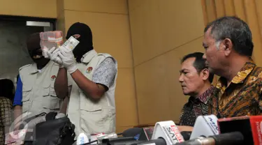 Petugas KPK menunjukkan barang bukti yang diperoleh dari operasi tangkap tangan (OTT) terkait dugaan suap DPRD DKI Jakarta disaksikan pimpinan KPK, Jakarta, Jumat (1/4). (Liputan6.com/Helmi Afandi)