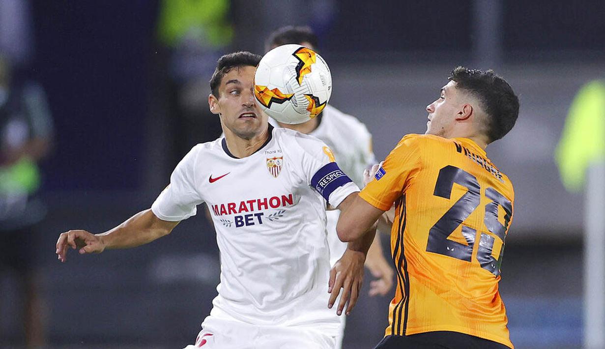 Pemain Sevilla, Jesus Navas, berebut bola dengan pemain Wolverhampton Wanderers, Ruben Vinagre, pada perempat final Liga Europa, Selasa (11/8/2020). Sevilla menang dengan skor 1-0. (Friedemann Vogel, Pool Photo via AP)