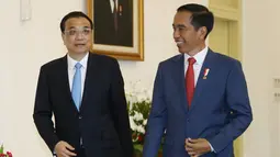 Presiden Joko Widodo berjalan bersama Perdana Menteri China Li Keqiang saat menyambut kedatangannya di Istana Bogor (7/5). Disela pertemuan tersebut Presiden Jokowi juga memperkenalkan maskot Asian Games 2018. (AFP/Pool/Dita Alangkara)
