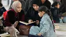 Diketahui, membaca Al Quran menjadi salah satu amalan utama untuk mendapatkan kemuliaan malam yang lebih baik dari seribu bulan tersebut. Tampak dalam foto, seorang wanita Muslim Syiah dan putrinya membaca Al-Quran, membaca Al-Quran, saat melaksanakan Itikaf di Masjid Kufa, selatan Baghdad, Irak, pada 12 Maret 2026. (Qassem al-KAABI/AFP)