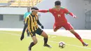 Gelandang Indonesia, Feby Eka Putra, menghindari kejaran pemain Malaysia pada laga Kualifikasi Piala Asia U-19 2018 di Stadion Public, Paju, Senin (6/11/2017). Indonesia kalah 1-4 dari Malaysia. (AFP/Kim Doo-Ho)