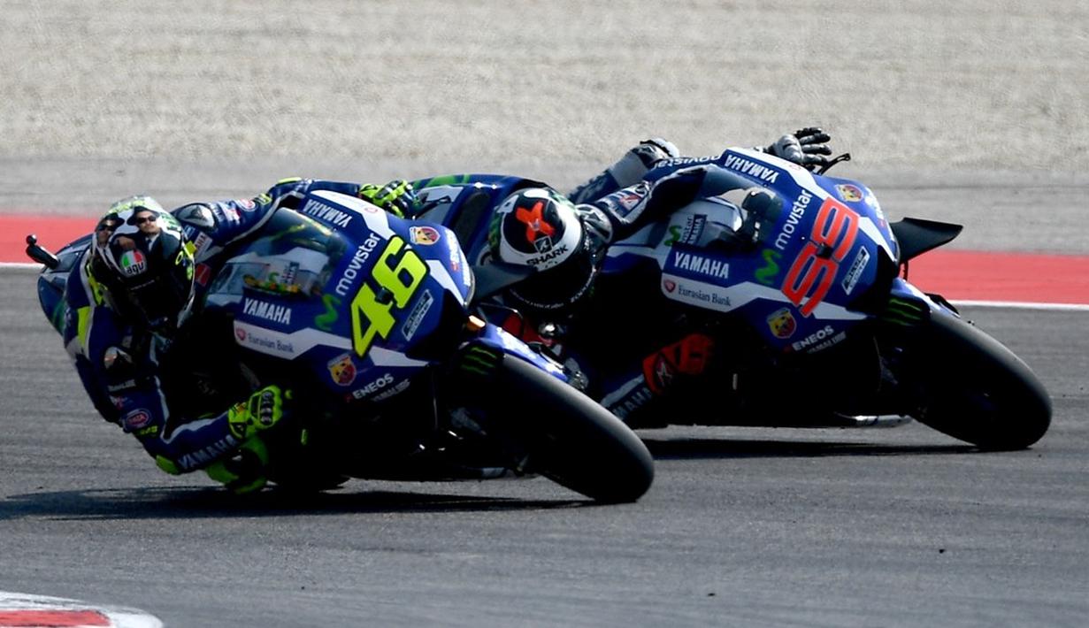 Dua pebalap Movistar Yamaha, Valentino Rossi (kiri) dan Jorge Lorenzo, bersaing ketat memperebutkan posisi kedua MotoGP San Marino di Sirkuit Misano, Minggu (11/9/2016). (AFP/Gabriel Bouys)