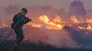 Seorang petugas pemadam kebakaran beroperasi di lokasi kebakaran hutan di Pumarejo de Tera dekat Zamora, Spanyol, 18 Juni 2022. Petugas pemadam kebakaran terus berjuang melawan beberapa kebakaran di Spanyol, salah satunya menghancurkan hampir 20.000 hektare lahan, pada hari terakhir gelombang panas ekstrem yang menghancurkan negara itu dengan puncaknya mencapai 43 derajat. (CESAR MANSO/AFP)
