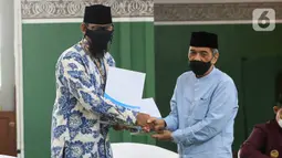 Co Founders the Rabbaanians Izzah Dani Prayoga dan Ketua YPI Al-Azhar Muhammad Suhadi berjabat tangan usai penandatanganan kerjasama dalam rangka memajukan perekonomian umat sesuai syariat menuju terbentuknya ekosistem UMKM syariah di Masjid Agung Al Azhar, Jakarta. (Liputan6.com/Fery Pradolo)