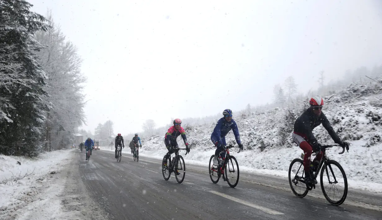 Deretan pebalap beraksi di bawah hujan salju dalam Etape 3 balap sepeda Paris-Nice antara Cusset dan Mont Brouilly, Prancis, (9/3/2016). (AFP/Kenzo Tribouillard)