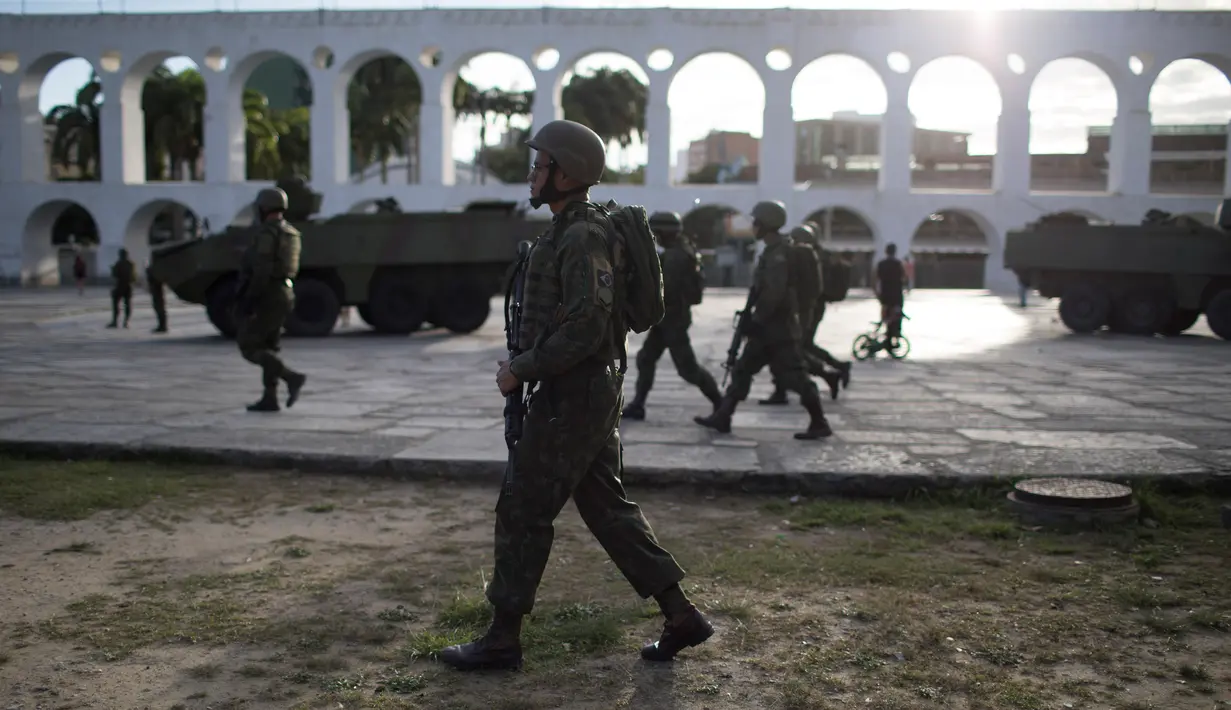 Sejumlah tentara patroli di lingkungan Lapa di Rio de Janeiro, Brasil, (30/7). Ribuan tentara mulai berpatroli di Rio de Janeiro di tengah lonjakan kekerasan di kota terbesar kedua di Brasil. (AP Photo / Leo Correa)
