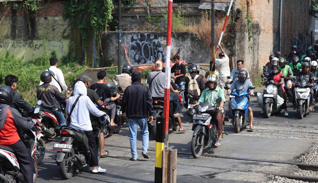 Palang pintu yang dipasang tampak berbahan besi berbentuk pipa dengan panjang sekitar kurang lebih 4 meter, yang menyesuaikan lebar jalan. Tampak dalam foto, situasi arus lalu lintas saat proses pemasangan palang pintu di perlintasan sebidang Jalan Ampera, dekat Stasiun Bekasi Timur, Bekasi, Jawa Barat. (Kapanlagi.com/Budy Santoso)