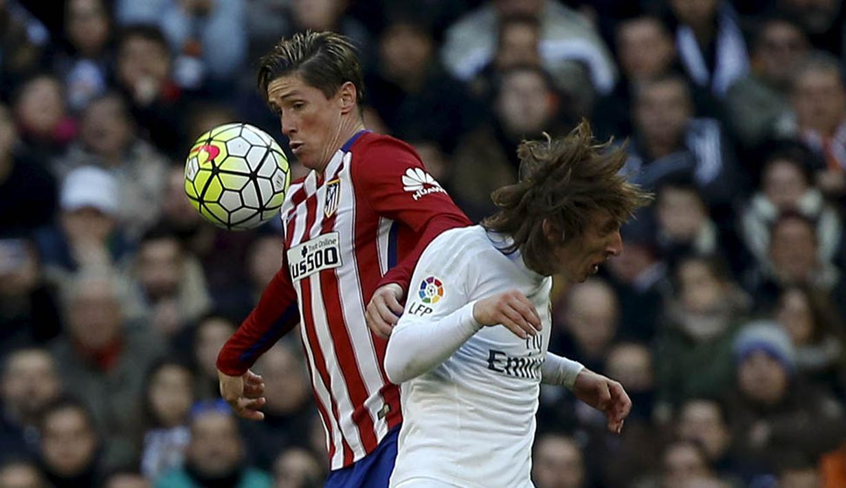 6. Striker Atletico Madrid, Fernando Torres, berebut bola dengan gelandang Real Madrid, Luka Modric, pada laga La Liga Spanyol di Stadion Santiago Bernabeu, Sabtu (27/2/2016). Real Madrid takluk 0-1 dari Atletico. (Reuters/Sergio Perez)