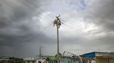Beberapa pekerja memperbaiki jaringan listrik yang rusak akibat Topan Rammasun yang memporak-porandakan kota Zhanjiang di provinsi Guangdong, (20/7/2014). (REUTERS/Stringer)