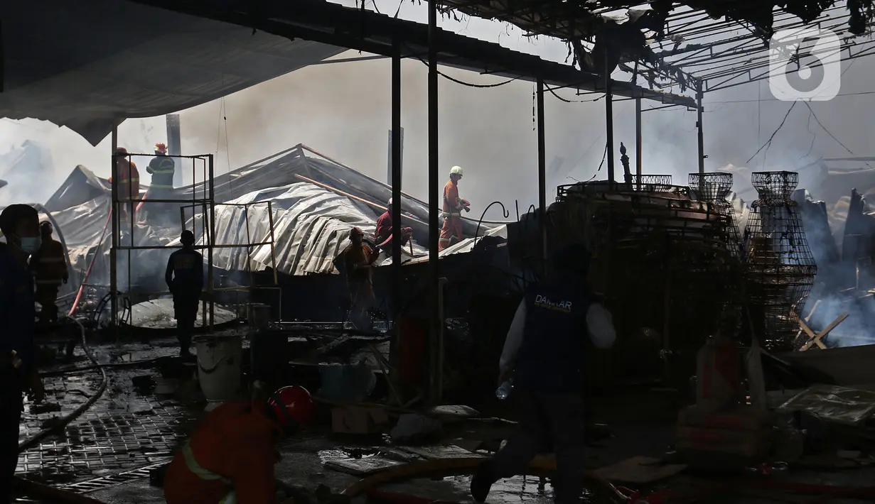 Petugas pemadam berada di lokasi kebakaran yang melanda gudang alat pesta di kawasan Cinangka, Depok, Senin (2/8/2021). Banyaknya bahan dari kayu serta bahan yang mudah terbakar, membuat api dengan cepat menyambar dan menghanguskan isi dan bangunan gudang. (Liputan6.com/Herman Zakharia)