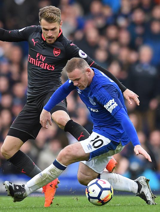 Penyerang Everton, Wayne Rooney (kanan) berebut bola dengan Aaron Ramsey (kiri) pada laga Premier League pekan ke-9 di Goodison Park, Liverpool, (22/10/2017). Arsenal menang 5-2. (AFP/Oli Scarff)
