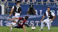 Striker Juventus, Cristiano Ronaldo berebut bola dengan pemain Cagliari, Paolo Farago dalam lanjutan Liga Italia di stadion Sardegna Arena, Rabu (29/7/2020). Juventus yang sudah menjadi juara terpeleset di markas Cagliari. (Alessandro Tocco/LaPresse via AP)