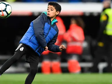 Putra Cristiano Ronaldo, Cristiano Ronaldo Jr berusaha mengontrol bola usai pertandingan antara Real Madrid dan Real Sociedad di stadion Santiago Bernabeu di Madrid, Spanyol (10/2). (AFP Photo/Gabriel Bouys)