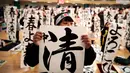 Peserta menampilkan tulisan Jepang mereka selama kontes kaligrafi  tahun baru di Tokyo, Sabtu (5/1). Sudah menjadi tradisi di Jepang jika semangat tahun baru digoreskan di atas kanvas dengan tulisan kaligrafi. (Behrouz MEHRI / AFP)