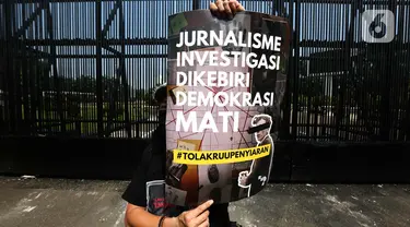 Salah satu pewarta membentangkan poster saat aksi penolakan terhadap revisi Rancangan Undang-Undang (RUU) Penyiaran di depan Gedung Kompleks Parlemen (MPR/DPR/DPD), Jakarta, Senin (27/5/2024). (Liputan6.com/Helmi Fithriansyah)