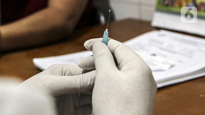 Petugas medis bersiap menyuntikkan vaksin COVID-19 Sinovac kepada tenaga kesehatan di Puskesmas Palmerah, Jakarta, Kamis (28/1/2021). Pemberian vaksin COVID-19 tahap kedua dilaksanakan terhadap tenaga kesehatan mulai hari ini. (Liputan6.com/Johan Tallo)