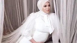 Dengan balutan busana putih, istri Rifky Balweel ini semakin cantik saja saat sesi maternity shoot. Ia memegangi perut besarnya sambil menatap anggun di sisi bagian kiri. Hanya berselang seminggu dari maternity shoot, Biby melahirkan seorang anak laki-laki. (Liputan6.com/IG/@bibyalraen13)