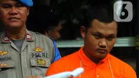 Ekspresi anggota Densus 88 Bripda Haris Sitanggang alias Bripda HS saat menjalani rekonstruksi pembunuhan sopir taksi online Sony Rizal Taihitu (56) di lapangan Direktorat Reserse Kriminal Umum Polda Metro Jaya, Jakarta, Kamis (16/2/2023). Bripda HS menjalani 37 adegan sebagai rangkaian peristiwa pembunuhan Sony Rizal Taihitu di Jalan Nusantara Perumahan Bukit Cengkeh, Kelurahan Tugu Cimanggis, Depok, Jawa Barat. (merdeka.com/Imam Buhori)