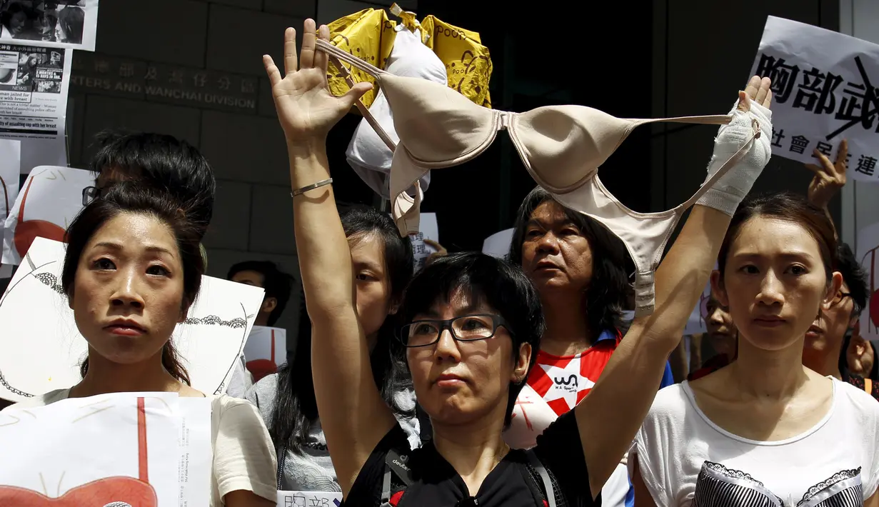 Pengunjuk rasa memegang bra di luar markas polisi di kawasan Wan Chai, Hong Kong, Minggu (2/8). Demo tersebut merupakan aksi simpati terhadap seorang perempuan yang di penjara karena dituduh menyerang polisi menggunakan payudaranya. (REUTERS/Tyrone Siu)