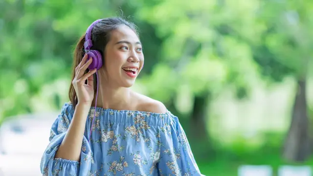 perempuan bahagia mendengarkan musik