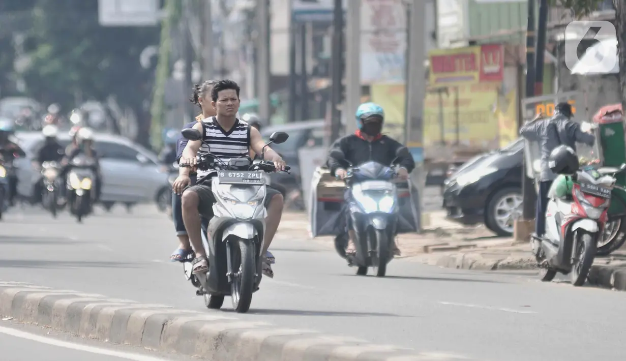 Pengendara sepeda motor tanpa mengenakan helm dan masker melintas di Jalan Pasar Minggu, Jakarta, Rabu (8/4/2020). Organisasi Kesehatan Dunia (WHO) telah merekomendasikan agar menggunakan masker saat berada di tempat umum demi memutus mata rantai penyebaran virus Corona. (merdeka.com/Iqbal Nugroho)